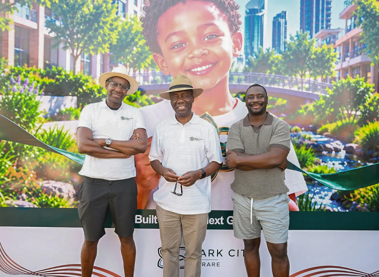 Three guests standing in front of the Phase One exhibition banner